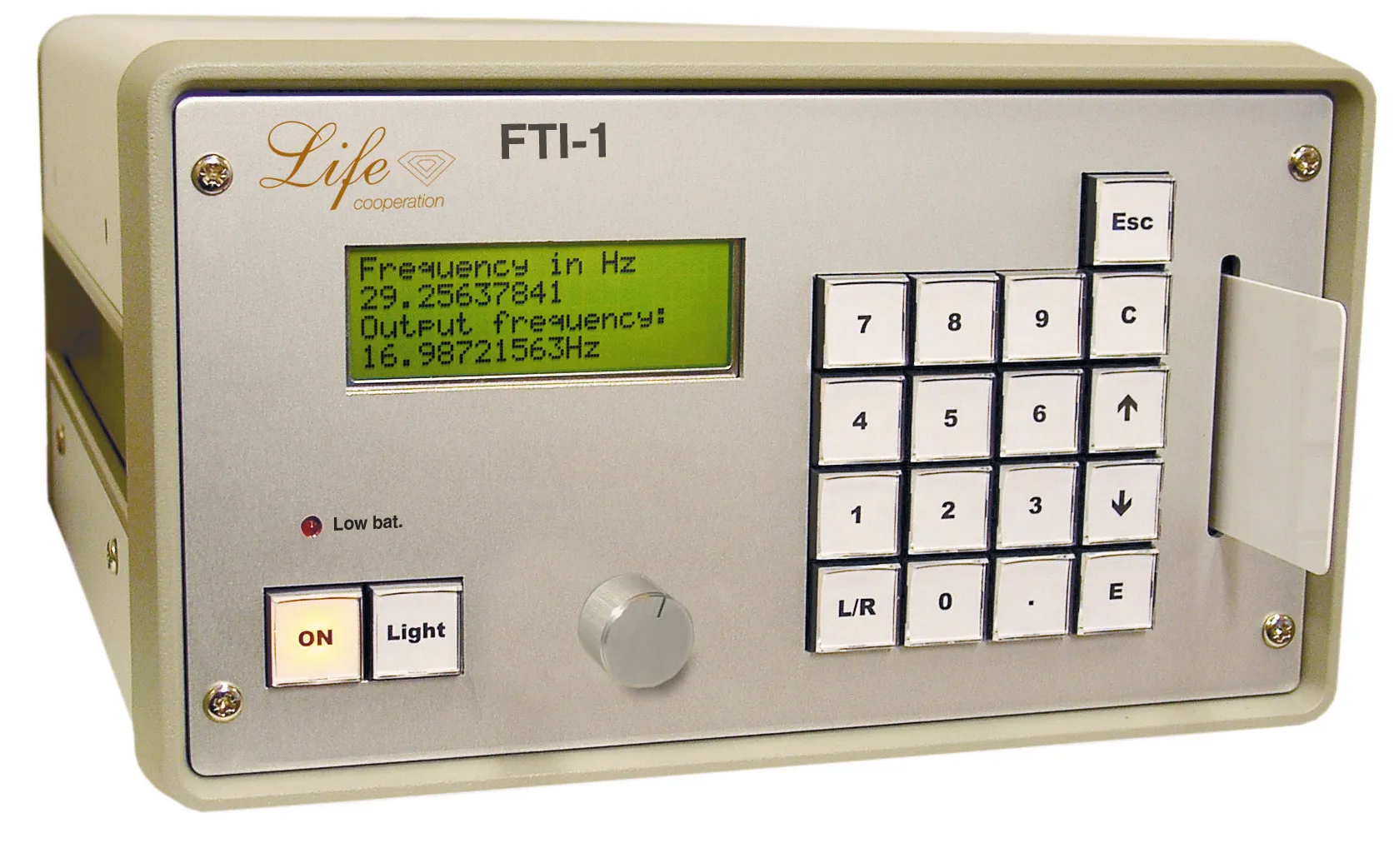 The FTI-1's front panel: a four-line display showing the entered and output frequencies, a numeric keypad with an L/R key for ear selection, and a level knob