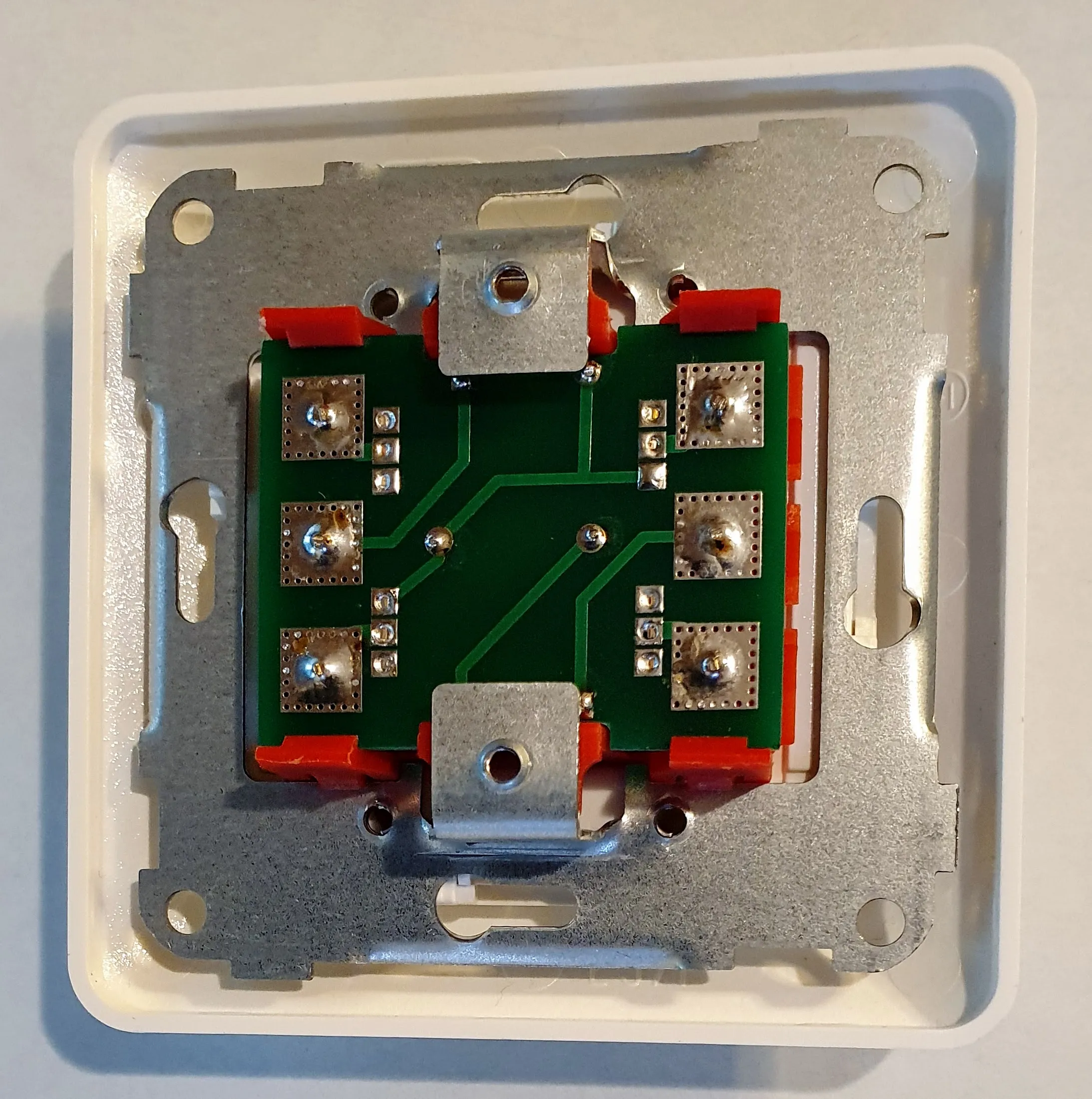The finished board mounted in the Elko socket frame, seen from behind, with the red rocker arms sitting over the soldered switch pads